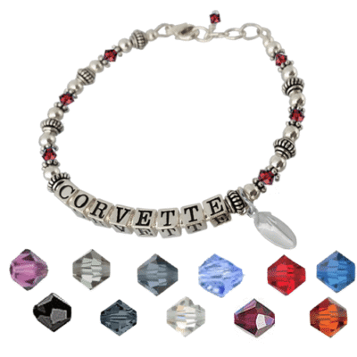Silver bracelet with "CORVETTE" beads, flanked by red crystals and silver spacers. Below are 11 faceted gemstones in various colors, enhancing elegance.