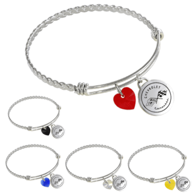 Silver bracelet featuring a twisted band with two charms: a black heart and a round disc engraved with a Chevrolet logo. Elegant and modern.