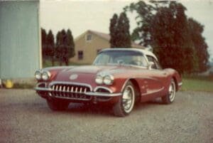 Red vintage convertible sports car without a hood parked on a driveway,
