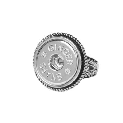 Silver ring featuring a round, coin-like design with the engraved text "Ginger Snaps" and decorative stars. The band is intricately detailed.